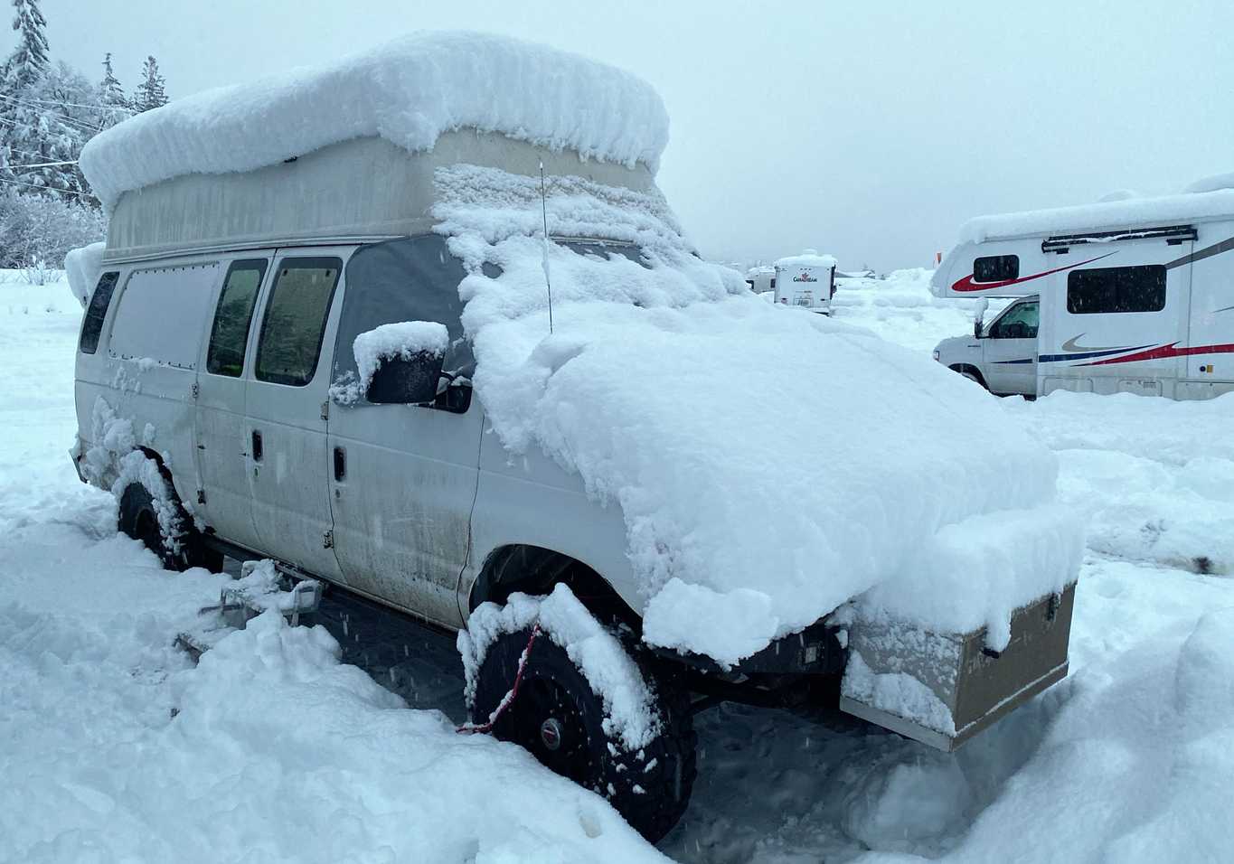 Snow piled up on our van after a big storm in the Revelstoke parking lot